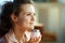 Happy stylish female with heart on cheek holding cosmetic jar