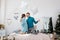 Happy stylish loving couple having a pillow fight in bed. young man and woman expecting baby for Christmas