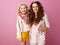 Happy stylish mother and daughter isolated on pink background