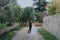 Happy stylish smiling couple walking in Tuscany, Italy on their wedding day. The bride and groom walk down the street by