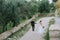 Happy stylish smiling couple walking in Tuscany, Italy on their wedding day. The bride and groom walk down the street by