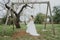 Happy stylish smiling couple walking in Tuscany, Italy on their wedding day. NEWLYWEDS WITH THE SWING IN THE PARK. The