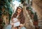 happy stylish tourist woman with map in old Italian town