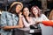 Happy stylish young women paying with credit card in shopping mall