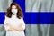 Happy successful doctor or nurse in medical face mask on Finnish flag background. Flu epidemic and virus protection in Finland