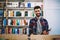 Happy successful hipster guy picking literature and making research in bookstore