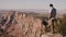 Happy successful young tourist man watching epic scenery over Grand Canyon mountains, wide cinematic background shot.