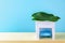 Happy Sukkot. A hut made of paper covered with leaves on a blue background. Copy the space.