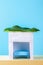 Happy Sukkot. A hut made of paper covered with leaves on a blue background. Copy the space.