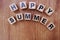 Happy summer alphabet on wooden background