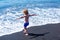 Happy summer. A boy is enjoying the ocean. A child on the beach runs in the waves of the warm ocean. Summer mood.