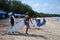 Happy surfers with surfboards along the sea shore going into the sea