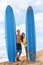 Happy surfers surfing couple posing with surfboard