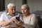 Happy surprised old couple reading message with unbelievable news.