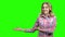 Happy surprised woman showing product on green screen.