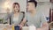 Happy sweet Asian couple having breakfast, cereal in milk, bread and drinking orange juice after wake up in the morning.