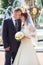 Happy sweet newly wedding couple standing near fountain