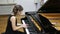 Happy talented young lady playing grand piano