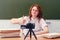 Happy teacher shows a gesture of success - thumbs up during an online lesson at school