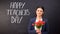Happy teachers day written on blackboard, smiling lady with tulips standing near