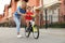 Happy  teaching her son to ride bicycle in city