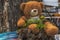 A happy teddy bear is sitting on a tree