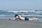 Happy teen boy having fun training or imitates swimming on the sand Ð¾n the beach