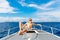 Happy teen boy in sunglasses on the yacht. Tropical sea in the b