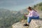 Happy teen checking smart phone in a cliff