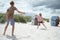Happy teen children joyful playing voleyball on white summer beach at holidays