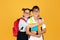 Happy teen european girl in glasses with backpack hugs boy with notebooks