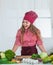 happy teen girl cooking vegetables. kid wearing professional chef uniform.