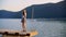 Happy teen girl dancing on pier near lake water