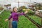 happy teen girl florist care pot plants in greenhouse, gardener