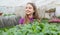 happy teen girl florist planting pot plants in greenhouse, agriculture