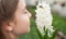 happy teen girl florist smell pot plants in greenhouse, gardener