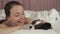 Happy teen girl kisses and plays with dog Papillon in bed