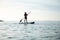 Happy teen girl paddling on sup board in Baltic sea