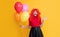 happy teen girl with party balloon on yellow background. wow