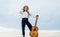 happy teen girl play acoustic guitar outdoor on sky background, singer