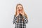 Happy teen girl shout and scream using her hands as tube, wearing casual plaid shirt, standing over white background