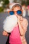 Happy teen girl in sunglasses eating cotton candy walking in city street