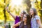 Happy teen girls taking selfie in park