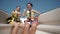 happy teen girls wearing safety belts rise hand up in the air and have fun on ride with luxury yacht