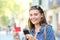 Happy teen holding credit card and phone in the street