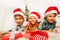 Happy teen kids with Santa hats and smiles