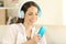 Happy teen listening to music using a blue smartphone