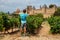 Happy teen overlook Carcassonne towers and walls from vineyard