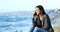 Happy teen talking on phone on the beach