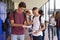 Happy teenage boys sharing exam results in school corridor